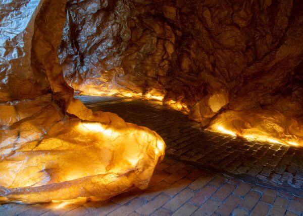 Detail of the Templum, showing the brown paper walls over a wire frame and lighting on the floor and a pathway through.