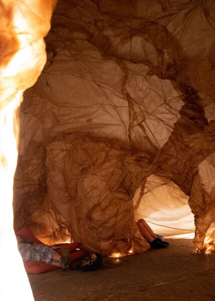 Detail of the Templum, showing the brown paper walls over a wire frame and showing a hole in the structure with cushions.